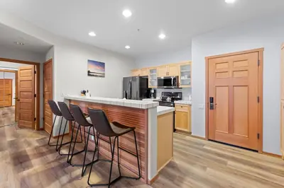 a kitchen with a bar with stools at Palisades Tahoe Lodge Rentals Two Bedroom #705 in Olympic Valley