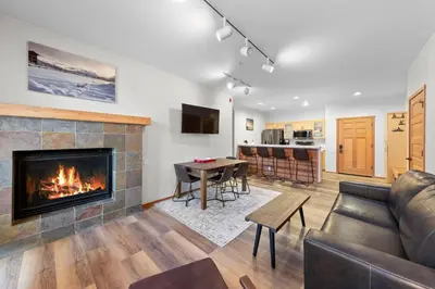 a living room with a fireplace and a table at Palisades Tahoe Lodge Rentals Two Bedroom #705 in Olympic Valley
