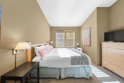 a bedroom with a bed and a desk and a television at Palisades Tahoe Lodge Rentals Two Bedroom #804 in Olympic Valley