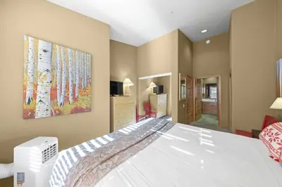 a bedroom with a white bed and a painting on the wall at Palisades Tahoe Lodge Rentals Two Bedroom #804 in Olympic Valley