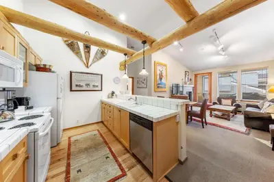 a kitchen with white appliances and a living room at Palisades Tahoe Lodge Rentals Two Bedroom #800 in Olympic Valley