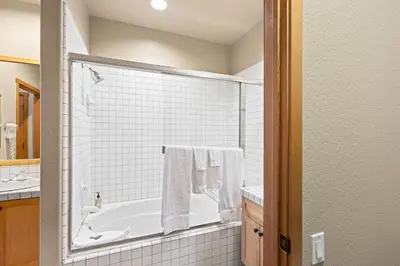 a white bathroom with a tub and a sink at Palisades Tahoe Lodge Rentals Two Bedroom #809 in Olympic Valley