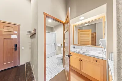 a bathroom with a toilet and a sink and a mirror at Palisades Tahoe Lodge Rentals Two Bedroom #809 in Olympic Valley