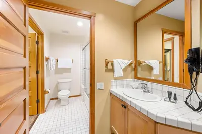a bathroom with a sink and a toilet and a mirror at Palisades Tahoe Lodge Rentals Two Bedroom #716 in Olympic Valley