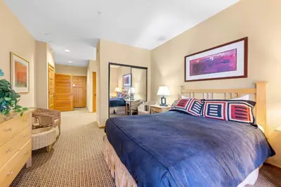 a hotel room with a large bed and a desk at Palisades Tahoe Lodge Rentals Two Bedroom #716 in Olympic Valley