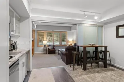 a kitchen and living room with a table and a couch at Palisades Tahoe Lodge Rentals Premium Studio #227 in Olympic Valley