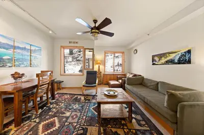 a living room with a couch and a table at Palisades Tahoe Lodge Rentals Premium Studio #243 in Olympic Valley