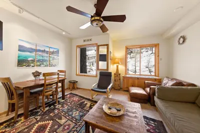 a living room with a couch and a table at Palisades Tahoe Lodge Rentals Premium Studio #243 in Olympic Valley