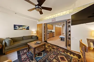 a living room with a couch and a table at Palisades Tahoe Lodge Rentals Premium Studio #243 in Olympic Valley
