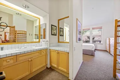 a bathroom with two sinks and a large mirror at Palisades Tahoe Lodge Rentals Two Bedroom #814 in Olympic Valley