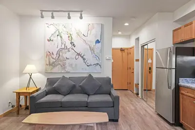 a living room with a couch and a kitchen at Palisades Tahoe Lodge Rentals Premium Studio #149 in Olympic Valley