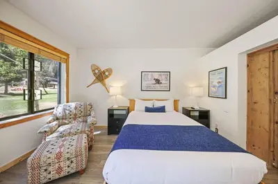 a bedroom with a large bed and a chair at Palisades Tahoe Lodge Rentals Premium Studio #149 in Olympic Valley