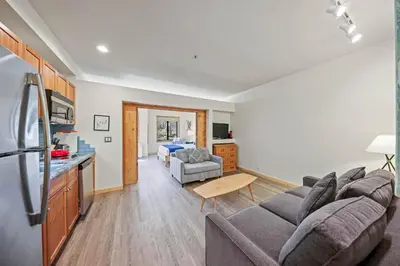 a living room with a couch and a kitchen at Palisades Tahoe Lodge Rentals Premium Studio #149 in Olympic Valley