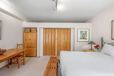 a bedroom with a bed and a desk and a table at Palisades Tahoe Lodge Rentals Studio #143 in Olympic Valley