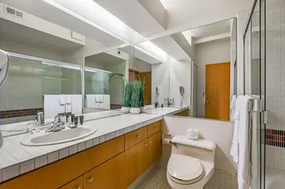 a bathroom with a sink and a toilet and a mirror at Palisades Tahoe Lodge Rentals Studio #104 in Olympic Valley
