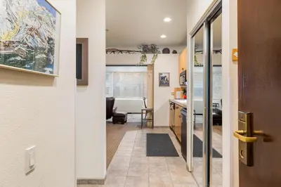 a hallway with a door leading to a kitchen with a table at Palisades Tahoe Lodge Rentals Studio #146 in Olympic Valley