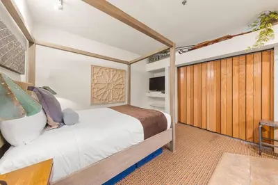 a bedroom with a bed and a wooden door at Palisades Tahoe Lodge Rentals Studio #146 in Olympic Valley