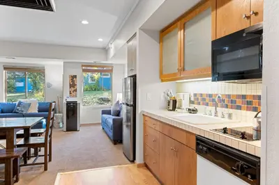 a kitchen with a sink and a dining room at Palisades Tahoe Lodge Rentals Studio #110 in Olympic Valley