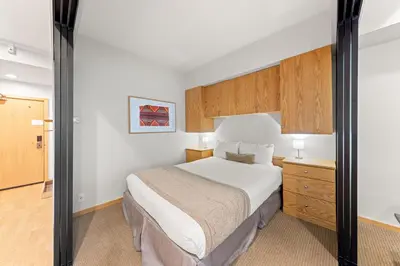 a hotel room with a bed and a dresser at Palisades Tahoe Lodge Rentals Studio #110 in Olympic Valley