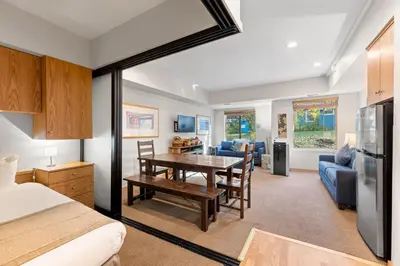 a kitchen and living room with a table in a room at Palisades Tahoe Lodge Rentals Studio #110 in Olympic Valley