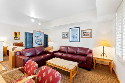 a living room with a couch and a bed at Palisades Tahoe Lodge Rentals Studio #115 in Olympic Valley