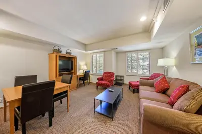 a living room with a couch and a table and a desk at Palisades Tahoe Lodge Rentals Studio #203 in Olympic Valley