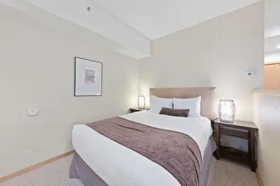 a bedroom with a large bed and two night stands at Palisades Tahoe Lodge Rentals Studio #113 in Olympic Valley