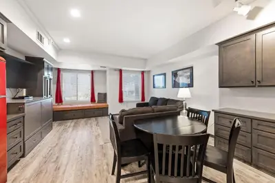 a kitchen and living room with a table and a couch at Palisades Tahoe Lodge Rentals Studio #117 in Olympic Valley