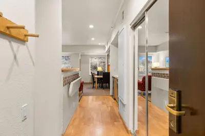 a hallway with white walls and a dining room at Palisades Tahoe Lodge Rentals Studio #118 in Olympic Valley