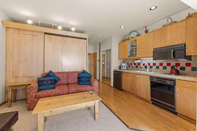 a living room with a couch and a kitchen at Palisades Tahoe Lodge Rentals Studio #147 in Olympic Valley