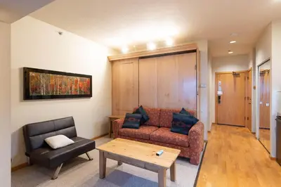 a living room with a couch and a chair at Palisades Tahoe Lodge Rentals Studio #147 in Olympic Valley
