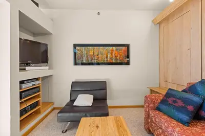 a living room with a couch chair and a television at Palisades Tahoe Lodge Rentals Studio #147 in Olympic Valley