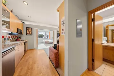 a kitchen with wooden cabinets and a door leading to a living room at Palisades Tahoe Lodge Rentals Studio #147 in Olympic Valley