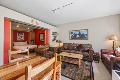 a living room with a couch and a bed at Palisades Tahoe Lodge Rentals Studio #151 in Olympic Valley