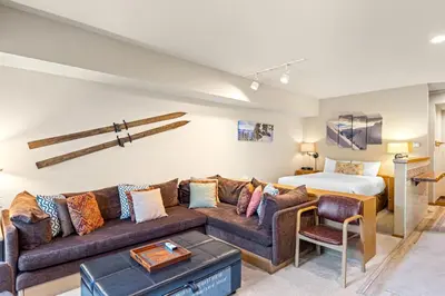 a living room with a couch and a bed at Palisades Tahoe Lodge Rentals Studio #207 in Olympic Valley
