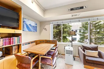 a dining room with a table and chairs and a tv at Palisades Tahoe Lodge Rentals Studio #207 in Olympic Valley