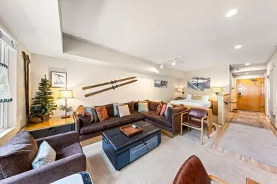 a living room with a couch and a bed at Palisades Tahoe Lodge Rentals Studio #207 in Olympic Valley