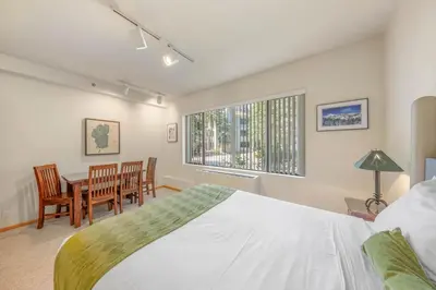 a bedroom with a bed and a table and chairs at Palisades Tahoe Lodge Rentals Studio #148 in Olympic Valley