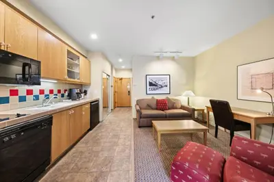 a living room with a couch a table and a kitchen at Palisades Tahoe Lodge Rentals Studio #155 in Olympic Valley