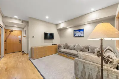 a living room with a couch and a flat screen tv at Palisades Tahoe Lodge Rentals Studio #211 in Olympic Valley
