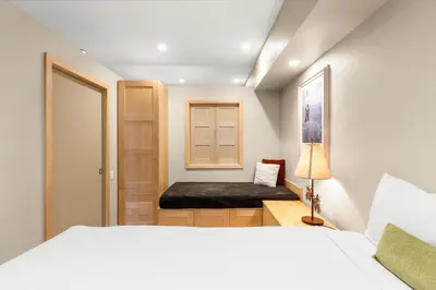a bedroom with a bed and a bench in it at Palisades Tahoe Lodge Rentals Studio #211 in Olympic Valley