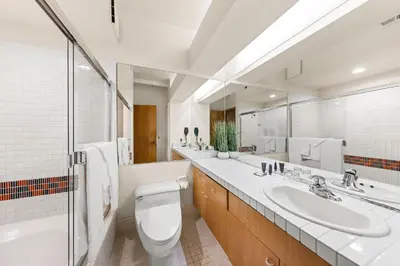 a bathroom with two sinks and a toilet and a mirror at Palisades Tahoe Lodge Rentals Studio #211 in Olympic Valley