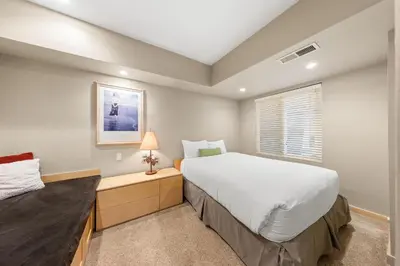 a bedroom with a large white bed and a window at Palisades Tahoe Lodge Rentals Studio #211 in Olympic Valley