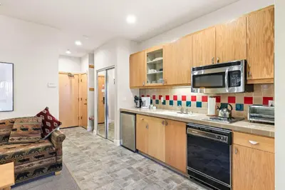 a kitchen with wooden cabinets and a microwave at Palisades Tahoe Lodge Rentals Studio #154 in Olympic Valley