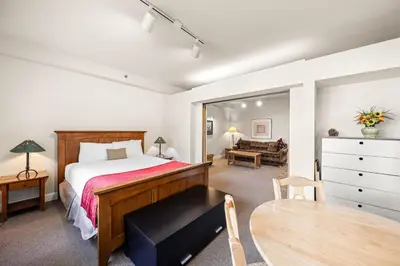 a bedroom with a bed and a table and a couch at Palisades Tahoe Lodge Rentals Studio #154 in Olympic Valley