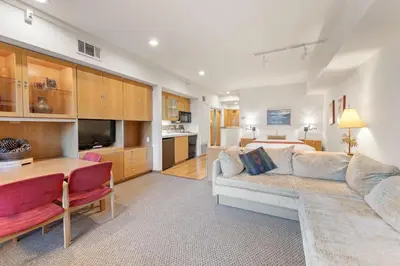 a living room with a couch and a dining room at Palisades Tahoe Lodge Rentals Studio #205 in Olympic Valley