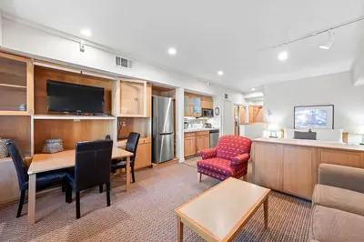a living room with a kitchen and a dining room at Palisades Tahoe Lodge Rentals Studio #215 in Olympic Valley