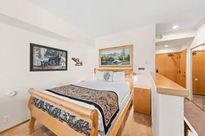 a small bedroom with a bed and a desk at Palisades Tahoe Lodge Rentals Studio #214 in Olympic Valley