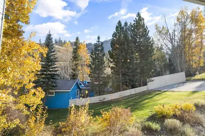 a blue house in the middle of a yard at Palisades Tahoe Lodge Rentals Studio #214 in Olympic Valley