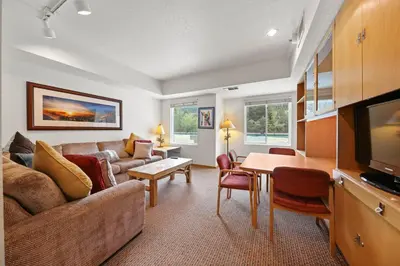 a living room with a couch and a table at Palisades Tahoe Lodge Rentals Studio #223 in Olympic Valley